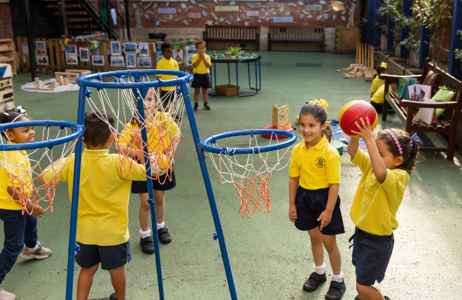reception children playing netball in playground
